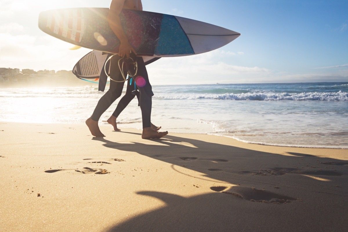 surfers walking into ocean