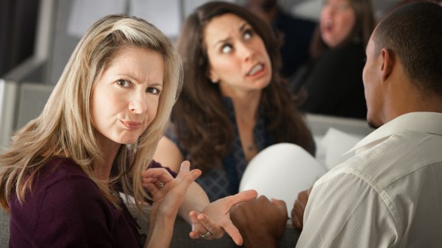woman frowning and pointing to another woman