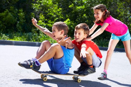 Copii care se joacă pe un skateboard