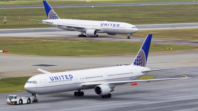 Two United Airlines planes taxiing on a runway