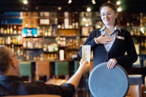 Waitress gets a tip from the client in the bar of the hotel.
