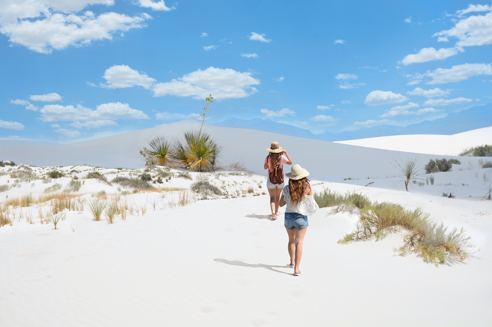Two young travelers walking through White Sands National Park