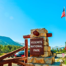 The entrance gate of Yosemite National Park with an American flag in the background