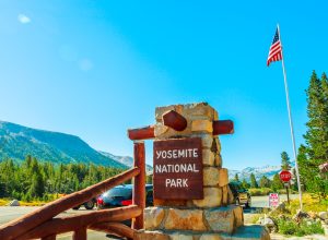 The entrance gate of Yosemite National Park with an American flag in the background