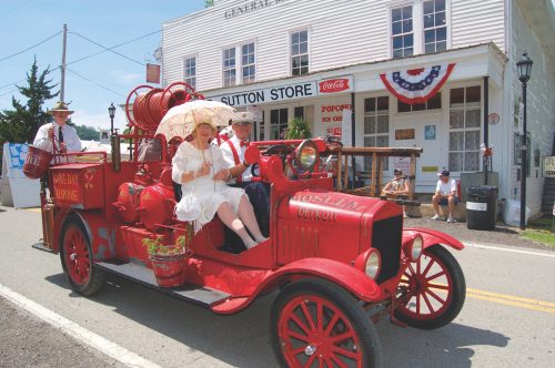 The Heritage Day parade in Granville, Tennessee. An old-time red car drives past the historic general store.