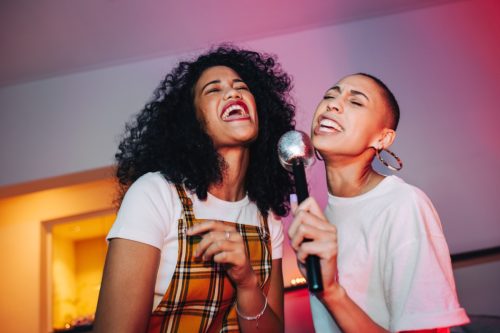 Two women singing together at karaoke