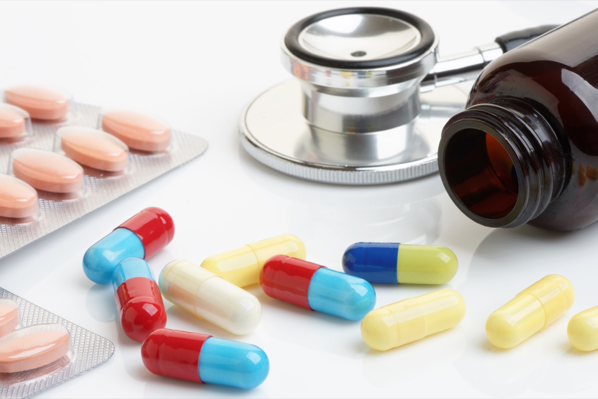Prim-plan cu pastile de statine, capsule și beta-blocante cu flacon și stetoscop.