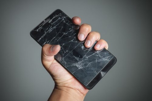 Cracked smartphone in hand holding.