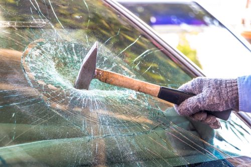 Technician use hammer for Broken car windshield. Selective focus.