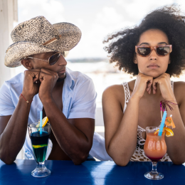 couple bored on vacation drinking cocktails