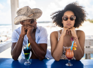 couple bored on vacation drinking cocktails