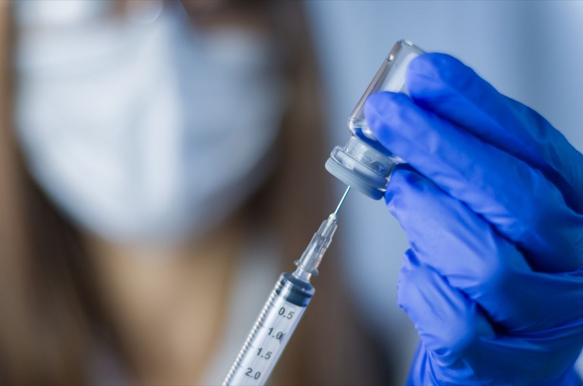 vaccine in researcher hands, female doctor holds syringe and bottle with vaccine for coronavirus cure. Concept of corona virus treatment, injection, shot and clinical trial during pandemic.