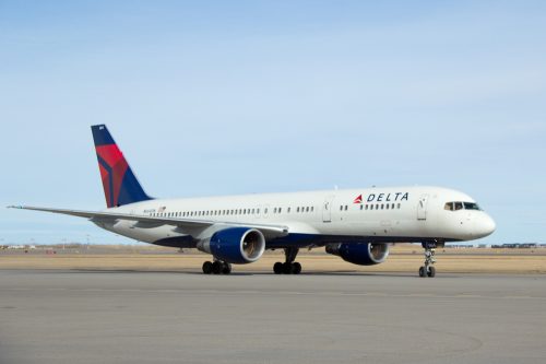 A Delta Air Lines plane sitting on the runway at an airport