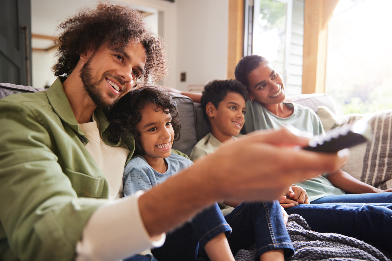 A family of four watching TV together