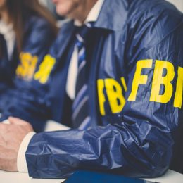Closeup of two FBI agents sitting in a conference room
