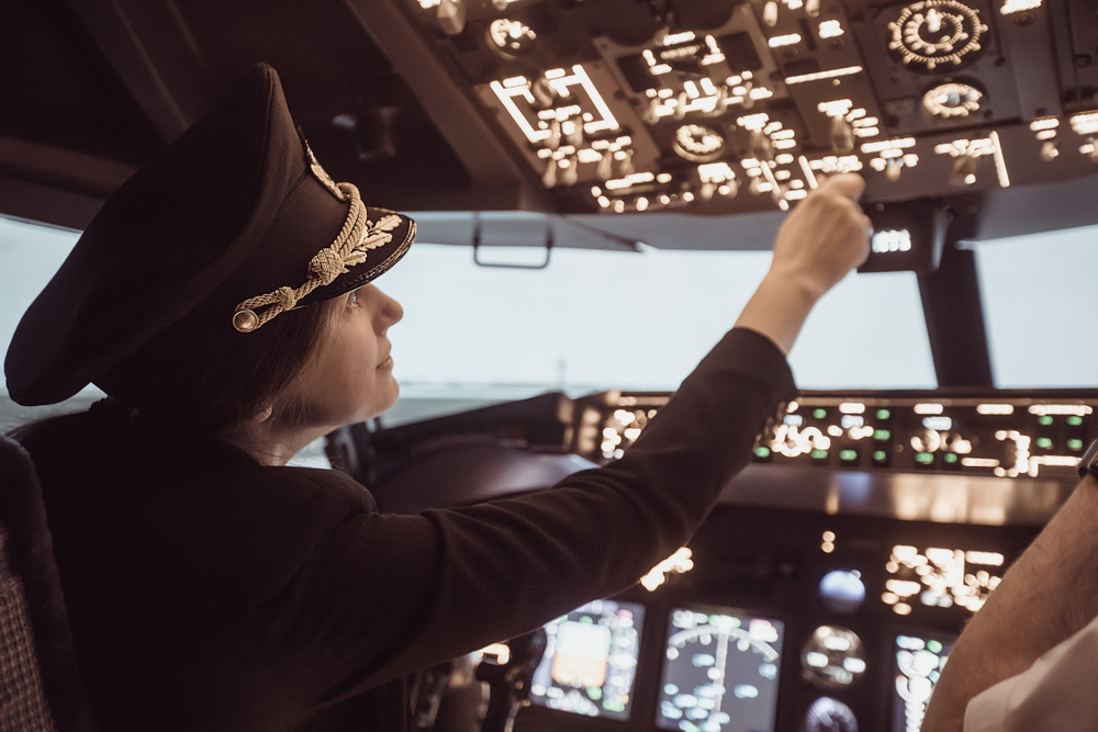 A female pilot in the cockpit of a commercial airliner