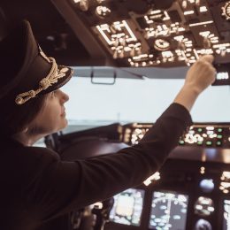 A female pilot in the cockpit of a commercial airliner