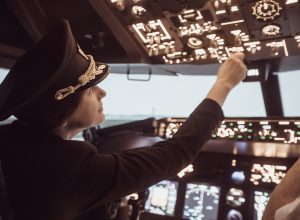A female pilot in the cockpit of a commercial airliner