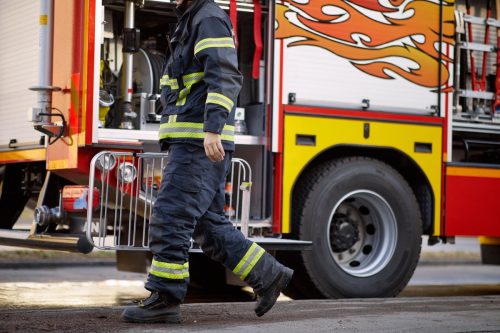 Fireman in uniform in front of fire truck going to rescue and protect. Emergancy , danger, servise concept.