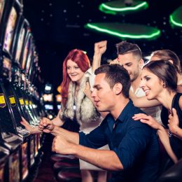 A group of friends playing slot machines