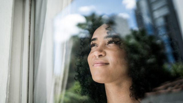 Woman smiling and looking out a window.