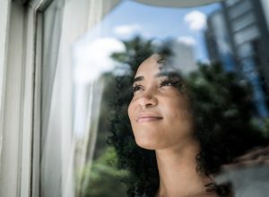 Woman smiling and looking out a window.