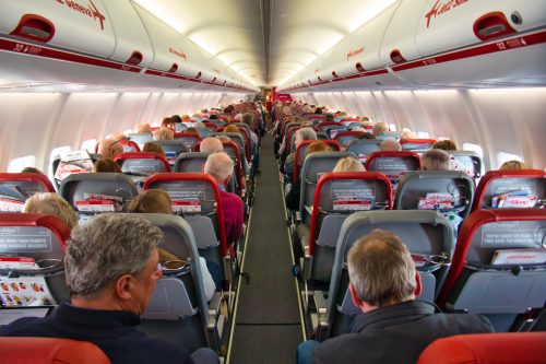 Passengers seating in a cabin of an airplane.