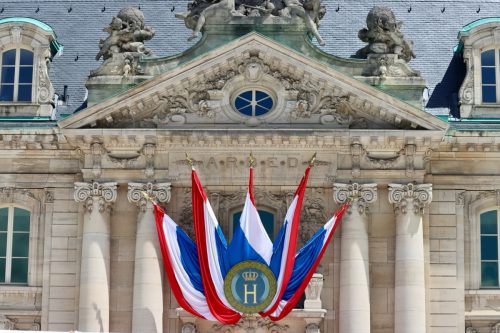 National day decorations on historic building in Luxembourg - flags with monogram H and crown for Grand Duke's Henry official birthday. Luxembourg