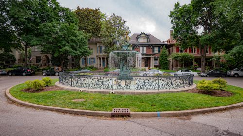 A fountain in Old Louisville, Kentucky, sitting in front of Victorian homes.