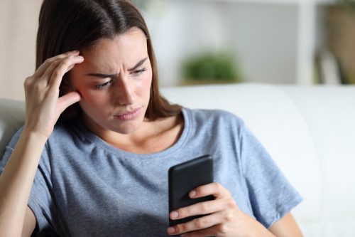 worried woman looking at cellphone