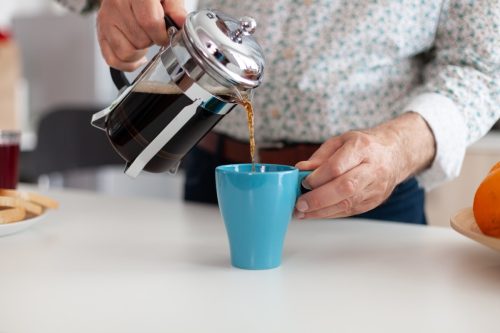 femeie turnând o ceașcă de cafea