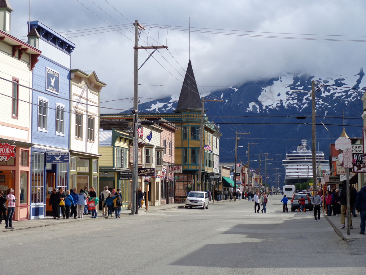 A main street of Skagway, Alaska with mountains in the backgroung
