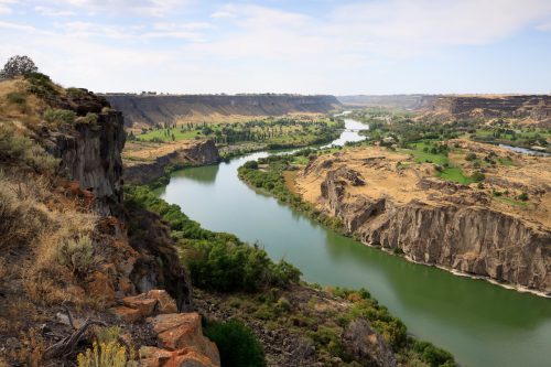 Snake River valley north of Twin Falls, Idaho. Rocky landscapes are seen along the green-blue water.