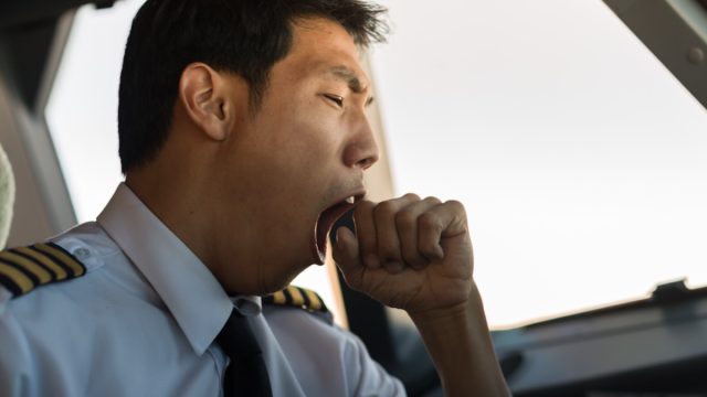 Tired man yawning at work.