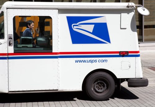 This image shows a USPS mail truck parked on the street near the Bellevue Square Mall in Washington State. You can see the mail delivery man standing on the far side of the truck.