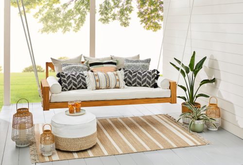 A porch swing with a lot of throw pillows advertising the Marrs Collection for Better Homes & Gardens at Walmart