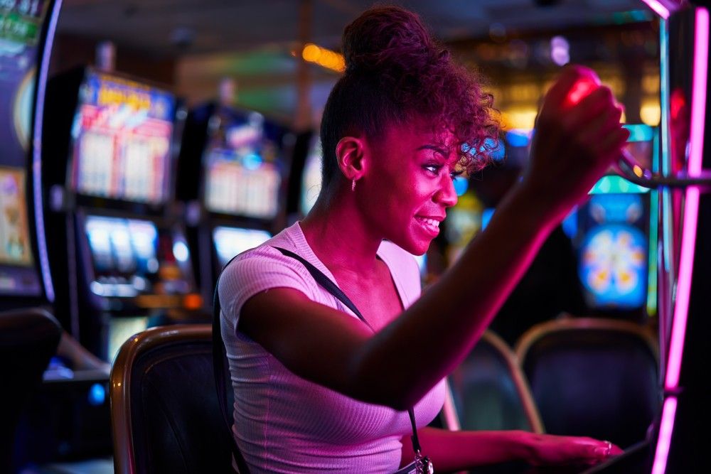 A woman playing on a slot machine in a casino.