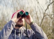 A man using binoculars while bird watching