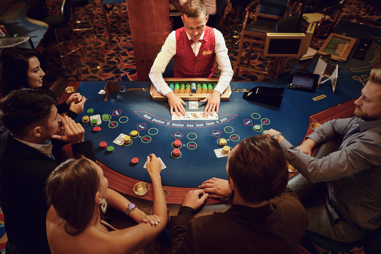 A card dealer at a crowded blackjack or poker table