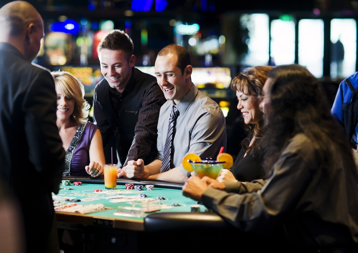 A group of people drinking at a cards table in a casino