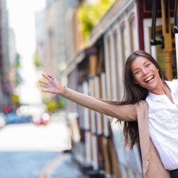 Happy Asian young woman excited having fun riding the popular tourist attraction tramway cable car system in San Francisco