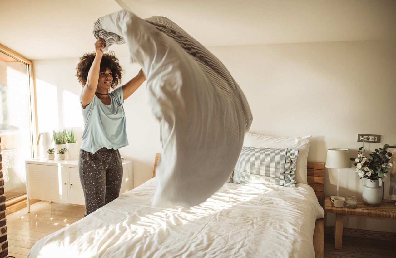 Woman making her bed.