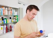 man looking at pill bottle