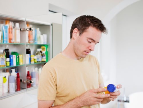 man looking at pill bottle