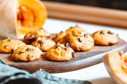 Pumpkin cookies with chocolate chips made from cake mix on a wooden tray.