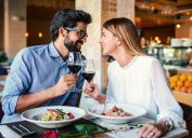 Romantic couple enjoying lunch in the restaurant, eating paste and drinking red wine. Lifestyle, love, relationships, food concept