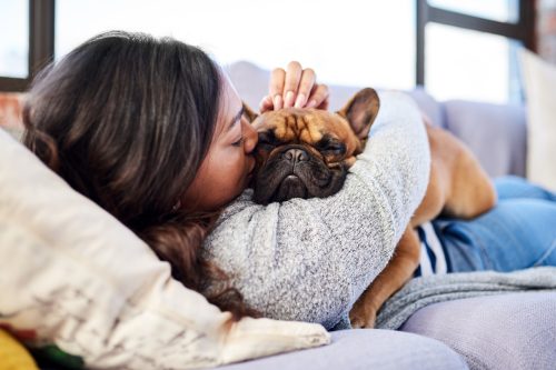 young woman relaxing with her dog on the couch