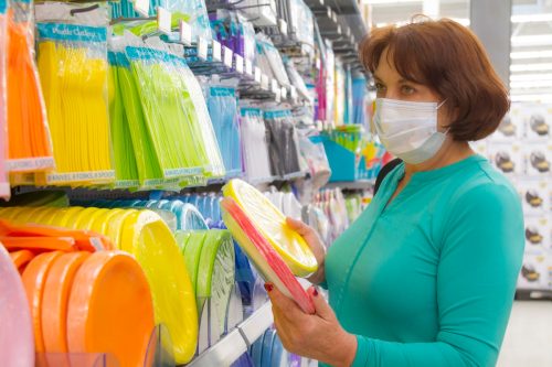 woman shopping for party supplies with mask on