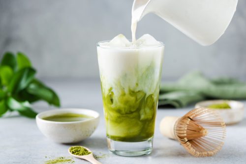 Soy milk pouring in matcha ice tea.