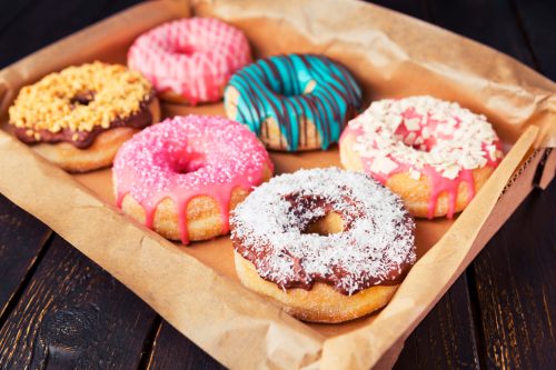A box with fresh homemade donuts with icing.